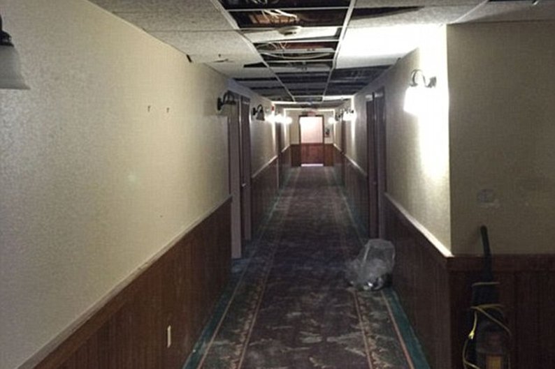 Corredor com teto quebrado no outro hotel que recebeu os universitários