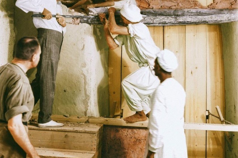Carter e alguns trabalhadores abrem a parede que separava a antecâmara da  câmara principal da tumba
