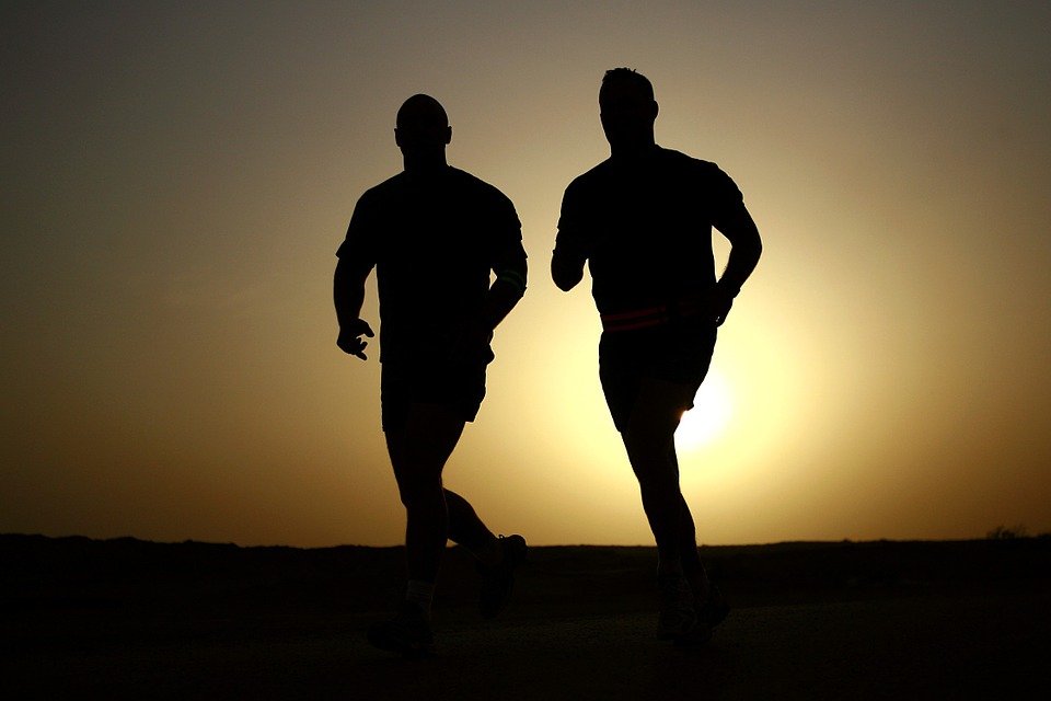 Homens correndo em pôr do sol