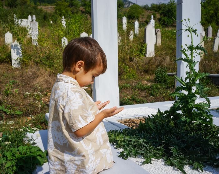 Garoto rezando no cemitério