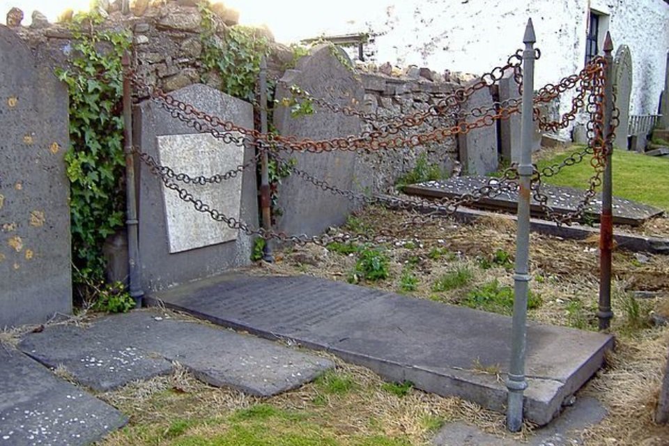 Imagem de Qual será o motivo de esta sepultura ficar rodeada por estacas e correntes? no megacurioso