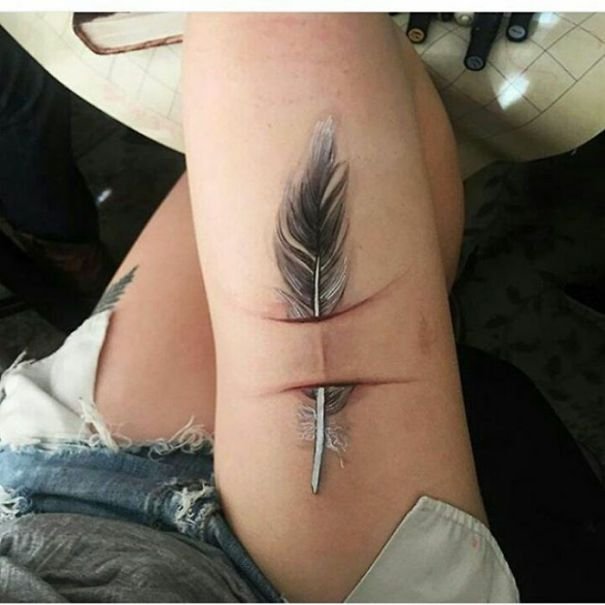 Pena tatuada na coxa