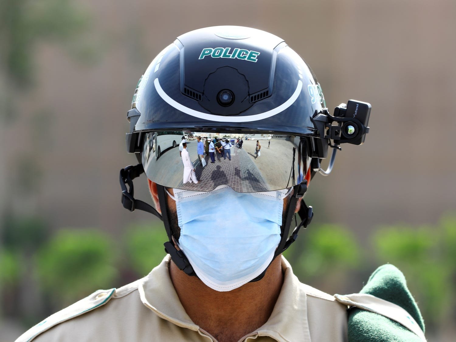 Um policial usa o capacete inteligente para verificar a temperatura de pessoas na rua em 23 de abril de 2020, Dubai