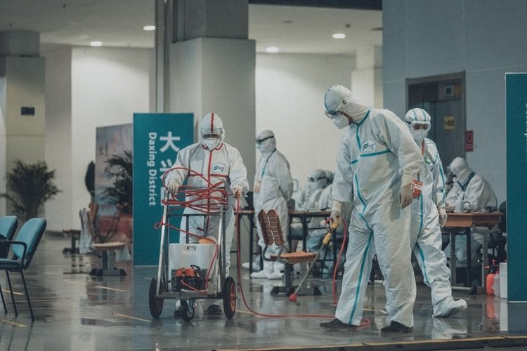 Funcionários limpam Hospital na Ásia com equipamentos de proteção. (Fonte: Unsplash)