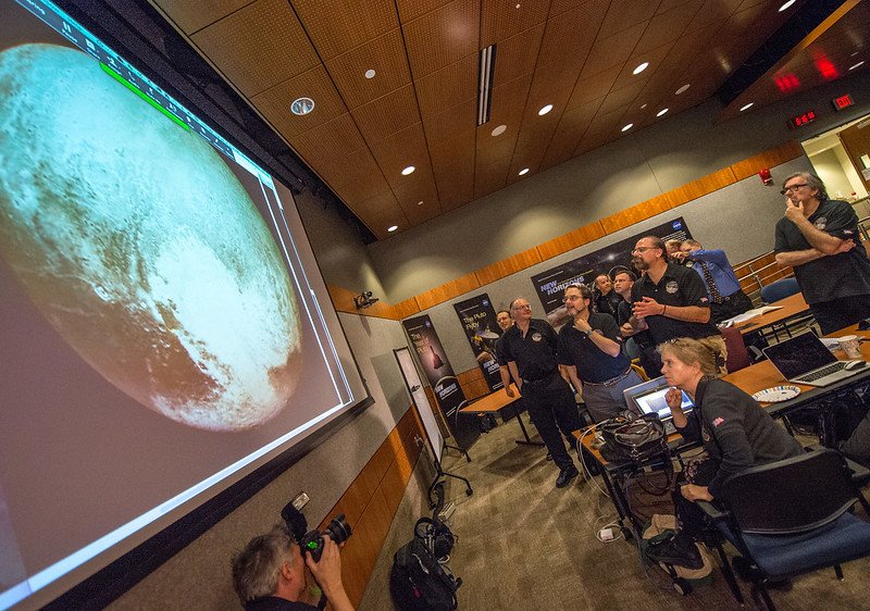 Equipe da NASA em reunião realizada em 2015 analisando as captações de imagens de Plutão (Fonte: NASA/Bill Ingalls)