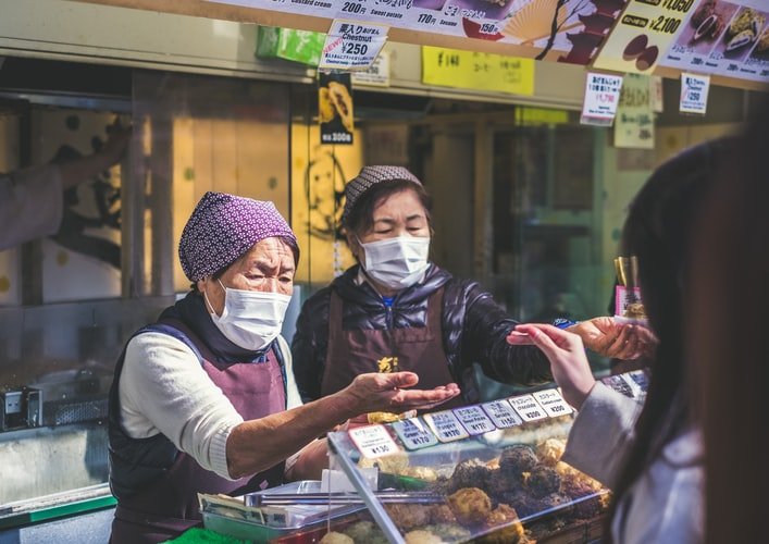 Feirantes usam máscaras de proteção durante a pandemia no Japão. (Unsplash/Reprodução)