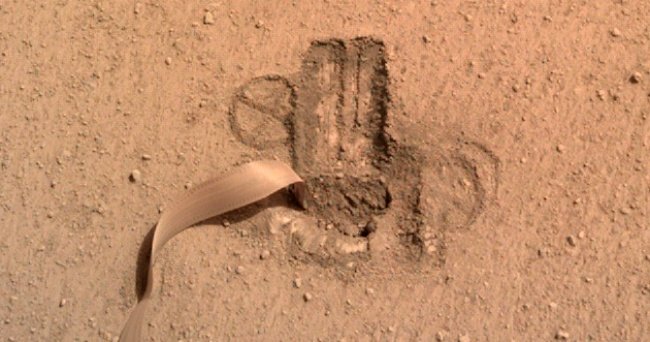 Na imagem mais recente, o instrumento já está quase totalmente coberto de areia e no interior do solo.