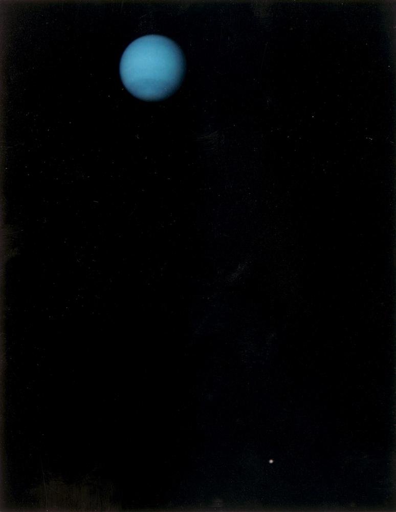 Em 3 de julho de 1989, a NASA recebeu da Voyager 2 essa imagem de Netuno e sua maior lua, Tritão (embaixo, à direita).