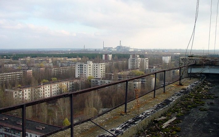 A usina ao fundo, vista de um telhado de edifício em Pripyat.