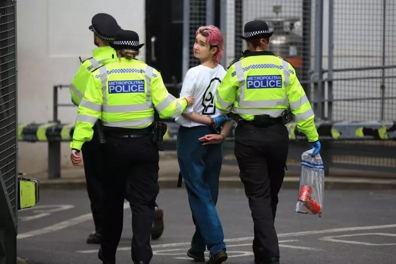 Ativista ecofascista faz sinal extremista branco ao ser presa. (Fonte: Martin Pope/Getty Images)
